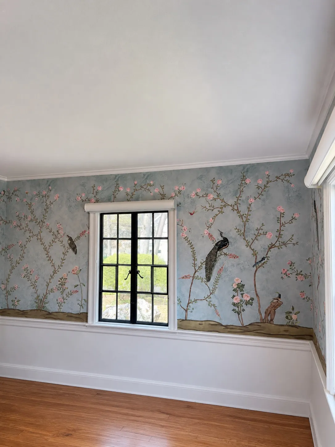 Professional wallpaper installer working on a wall